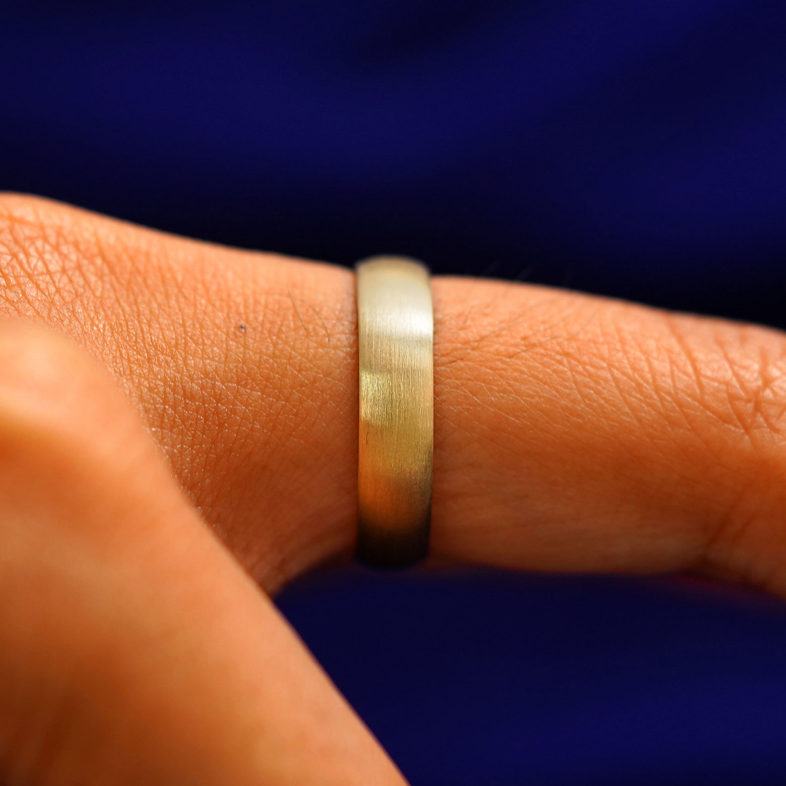 Side view of a Curvy Matte Band on a model's finger