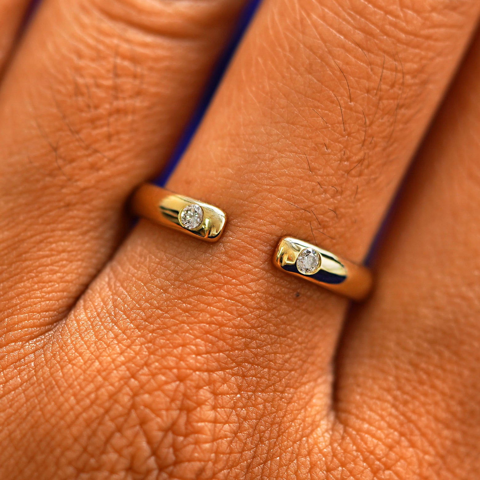 Close up view of a model's fingers wearing a 14k yellow gold Open Curvy Band