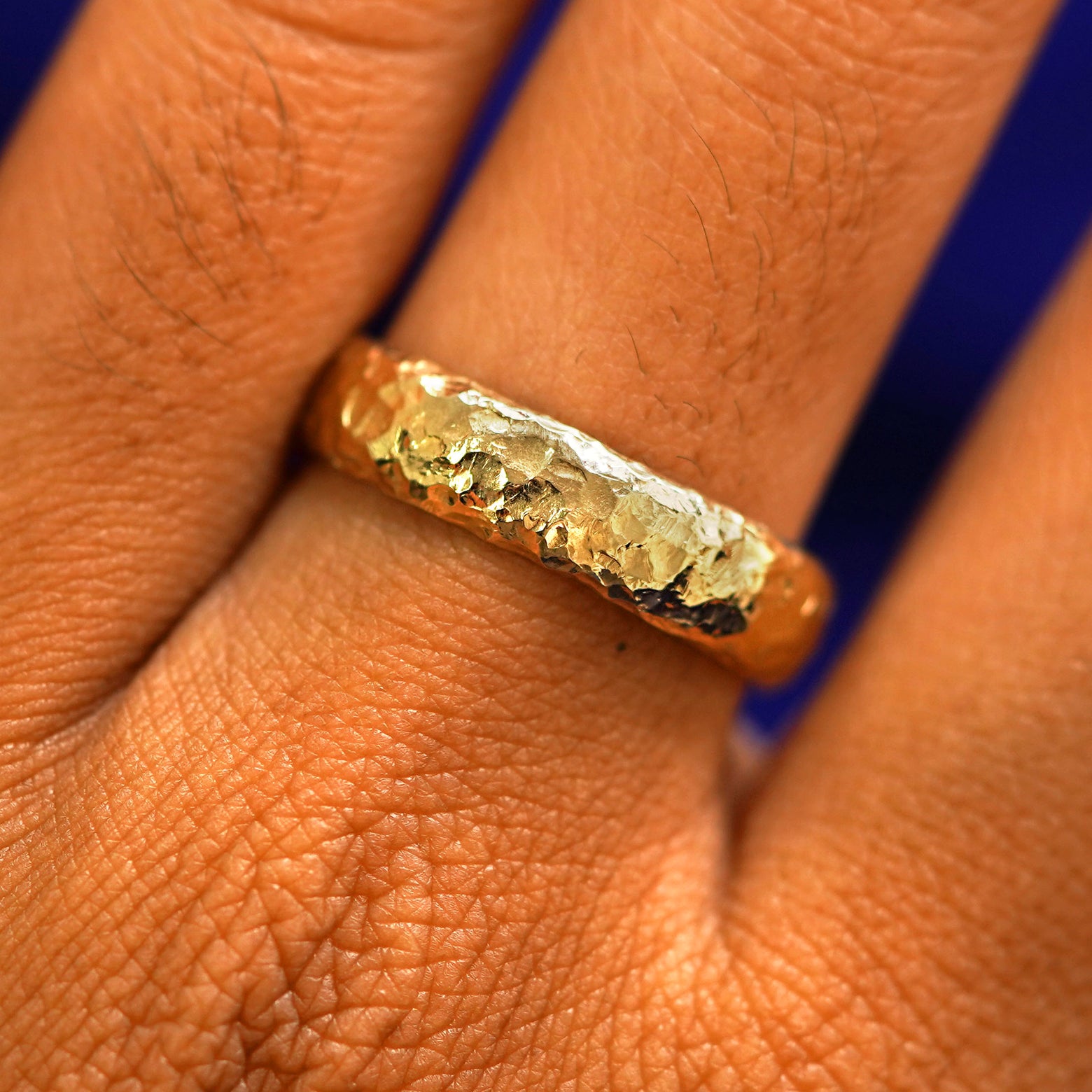 Close up view of a model's fingers wearing a 14k yellow gold Organic Band