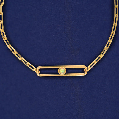 A yellow gold elongated open oval link with a single bezel set Opal inside on a 14k gold Butch chain necklace