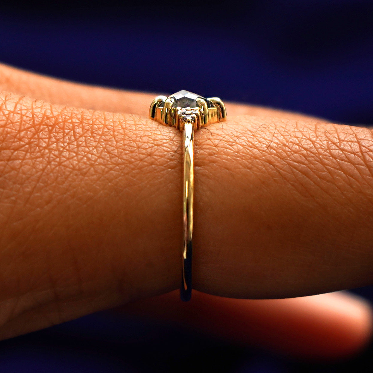 Side view of a Pear Salt and Pepper Diamond Ring on a model's finger to show the hidden halo