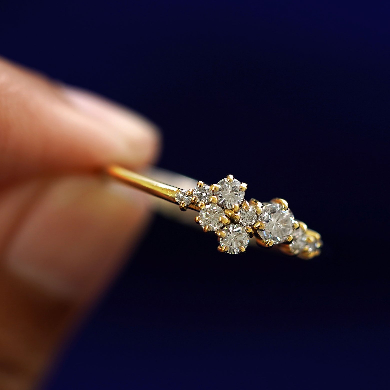A model holding a Diamond Cluster Ring tilted to show the detail of the diamond cluster