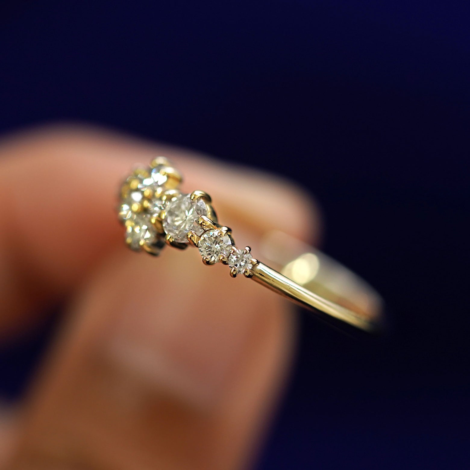 A model holding a Diamond Cluster Ring tilted to show the side of the ring