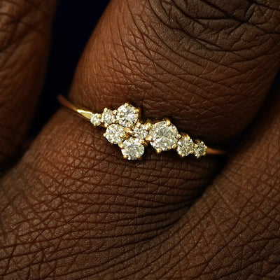 Close up view of a model's fingers wearing a 14k yellow gold Diamond Cluster Ring