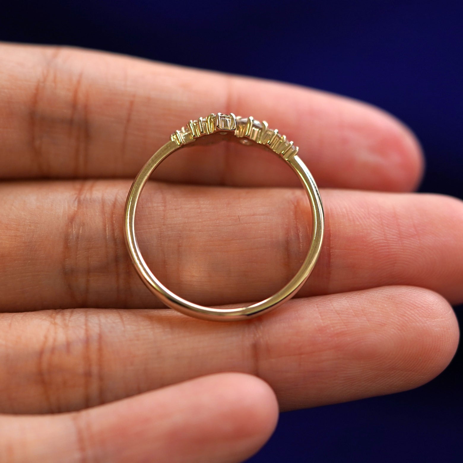A yellow gold Diamond Cluster Ring in a model's hand showing the thickness of the band