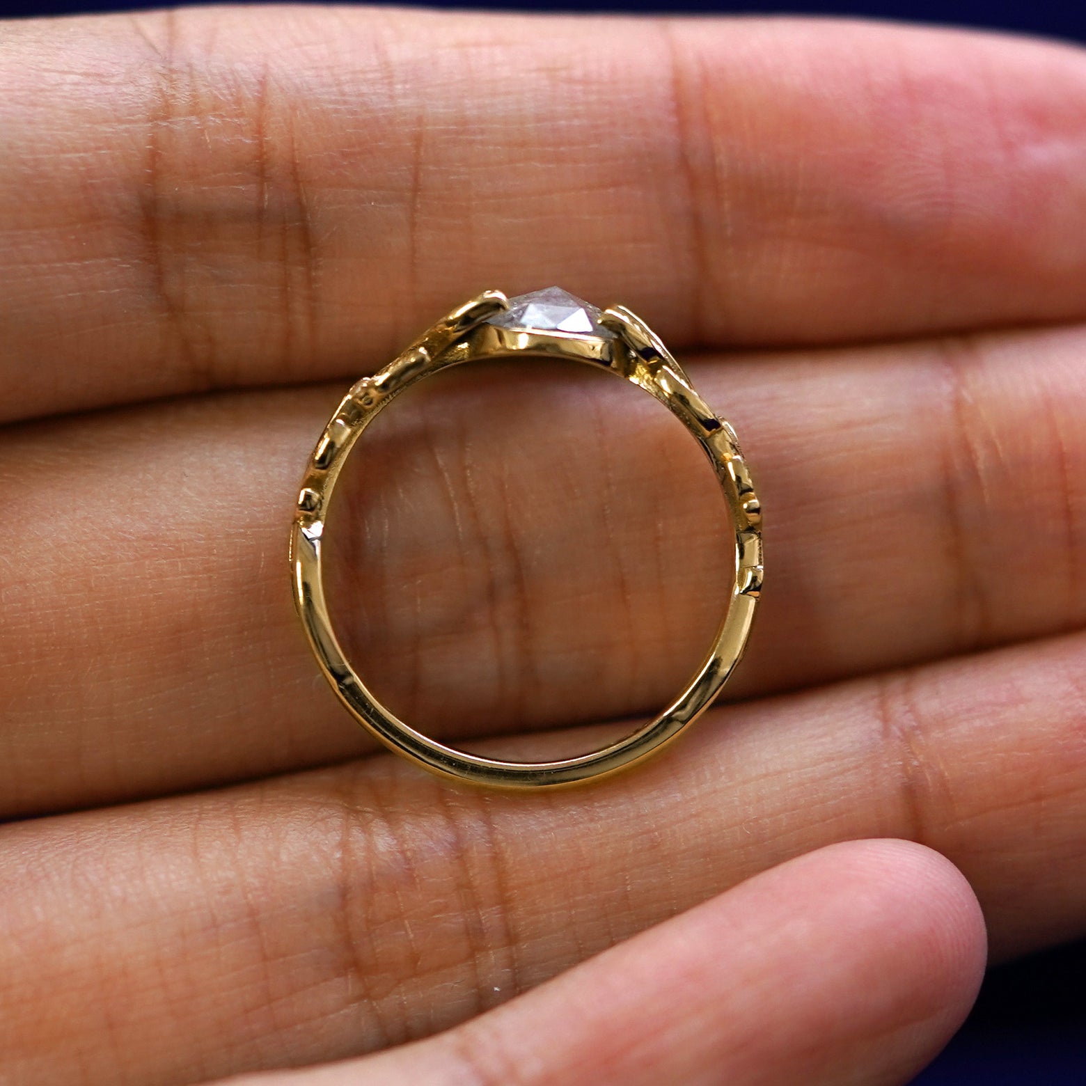 A yellow gold Diamond Leaves Ring in a model's hand showing the thickness of the band
