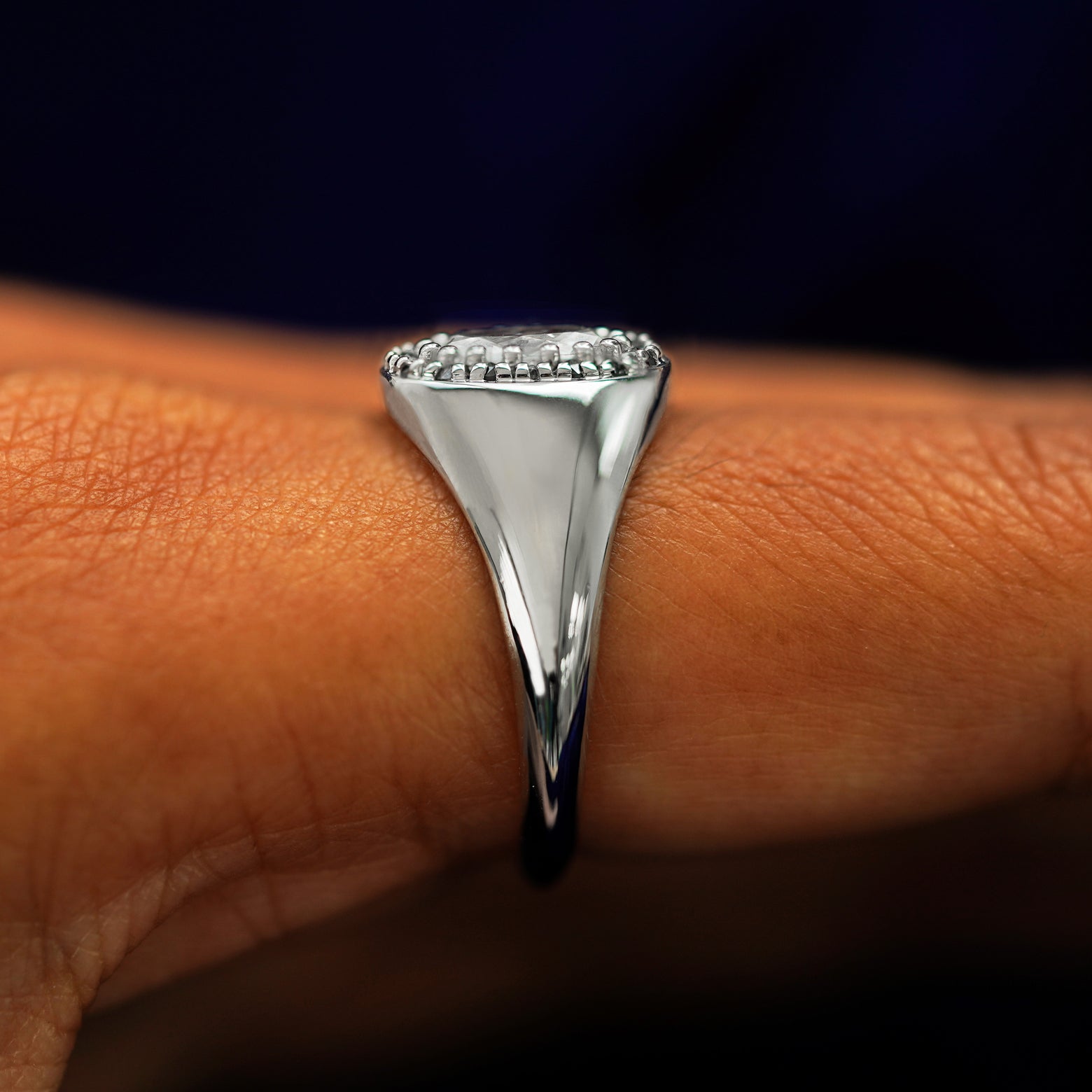 Side view of a Platinum Oval Diamond Signet Ring on a model's finger to show details