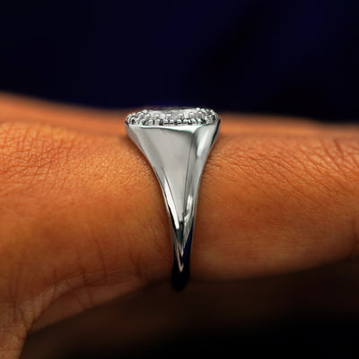 Side view of a Platinum Oval Diamond Signet Ring on a model's finger to show details