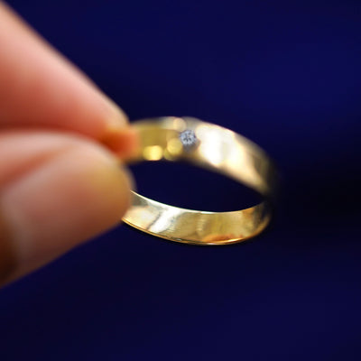 A yellow gold Diamond Industrial Band in a model's hand showing the thickness of the band