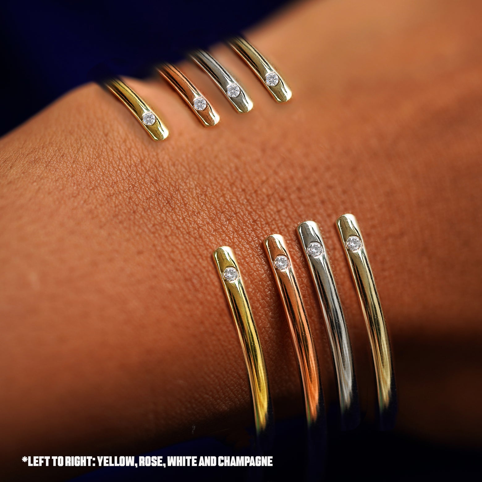 A model's wrist wearing four versions of the Diamond Open Bangle in options of rose, yellow, champagne, and white gold