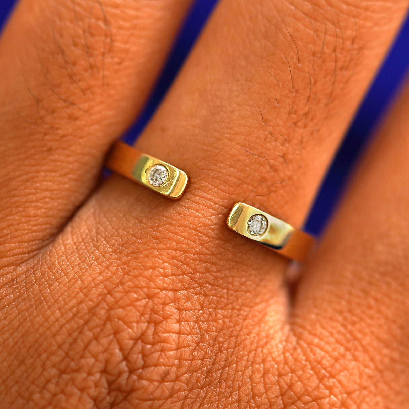 Close up view of a model's fingers wearing a 14k yellow gold Open Industrial Band