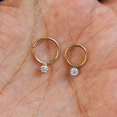 A 10mm pierced diamond septum and an 8mm pierced diamond septum resting in a model's palm