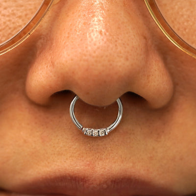 Close up view of a model's nose wearing a 14k white gold 3 Diamond Septum