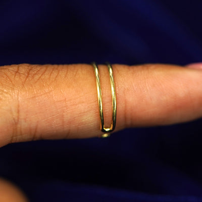 Side view of a model's finger wearing a solid gold Double Line Toe Ring