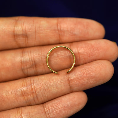 A solid 14k yellow gold Double Line Toe Ring resting on a model's fingers to show the thickness of the band