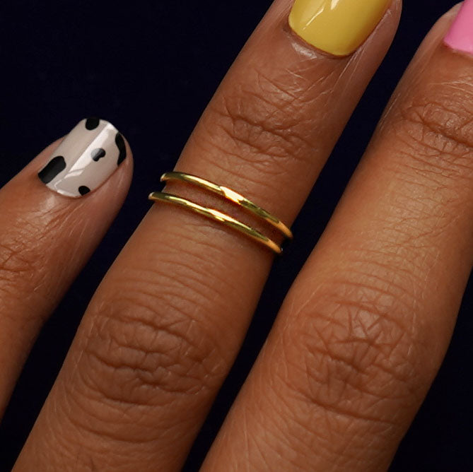 Four versions of the Double Line Toe Ring shown in options of yellow, white, rose and champagne gold