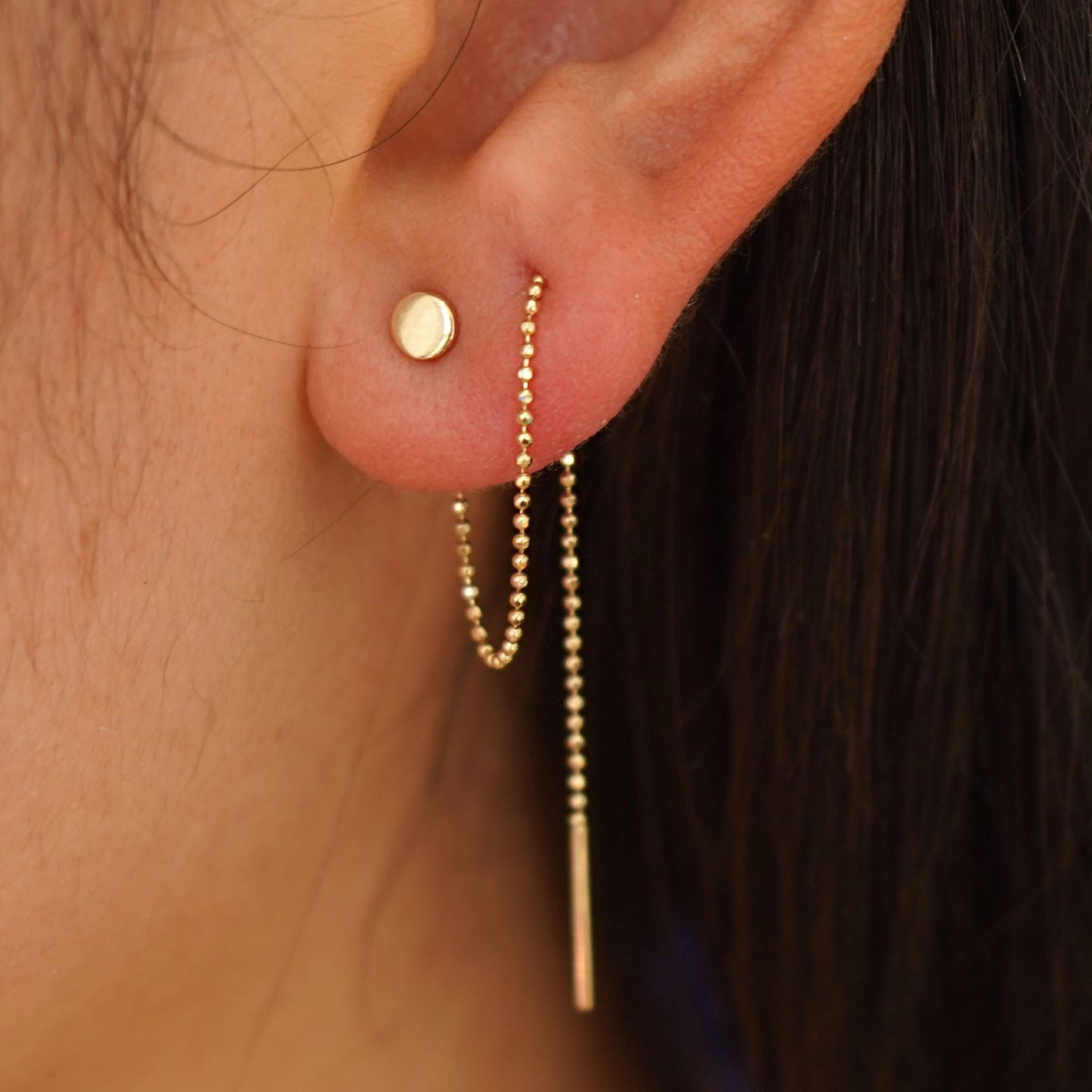 Close up view of a model's ear wearing a Circle Threader looped through two piercings