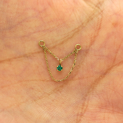 A solid 14k yellow gold emerald Cable Chain Connector sitting in a model's hand