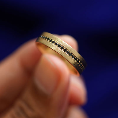 A model holding a Endless Diamond Band tilted to show the side of the ring