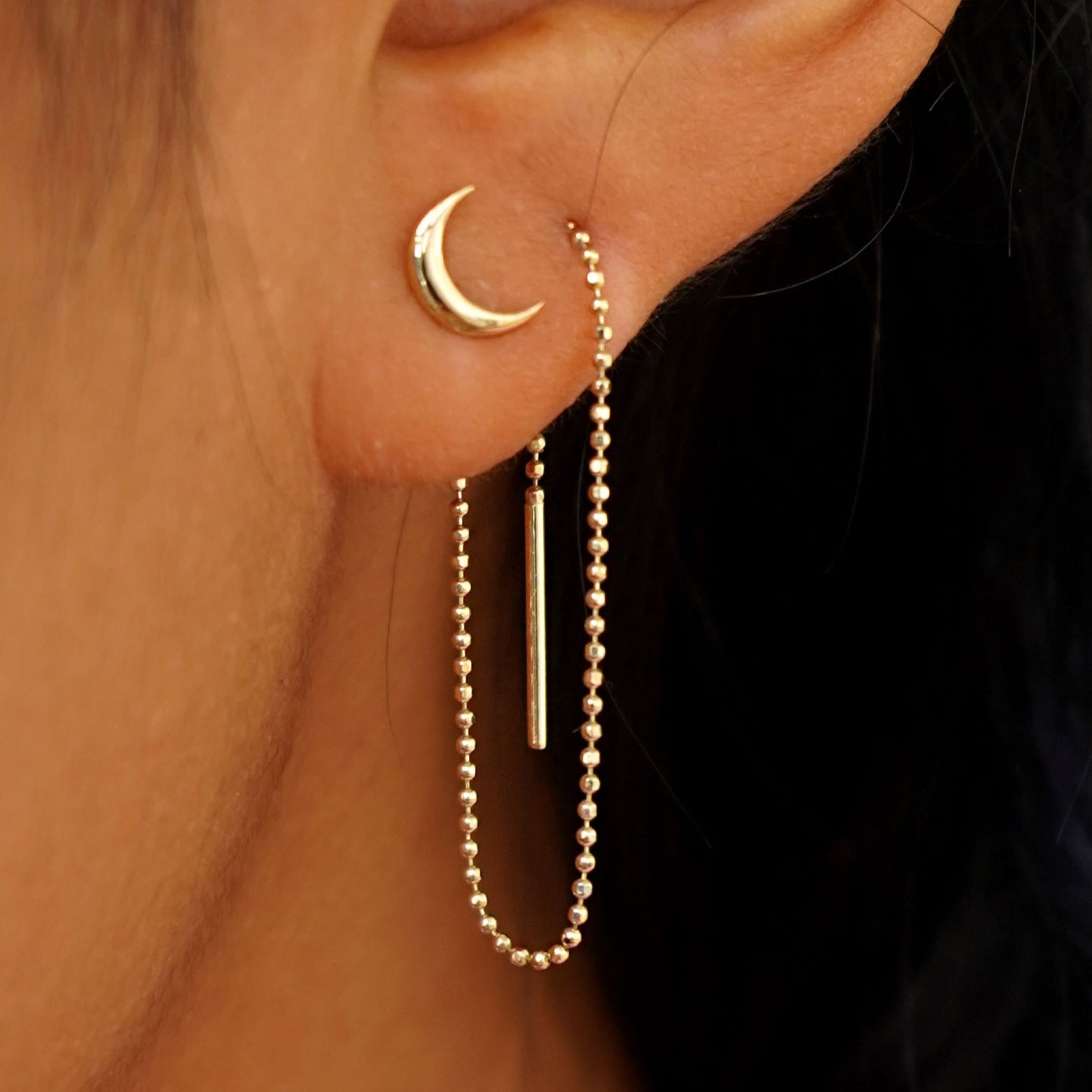 A model wearing a Moon Earring with an Extender attached at the back and threaded through the front of a second piercing