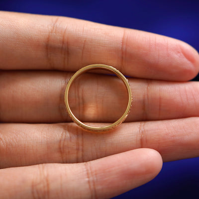 A Filigree Band resting in a model's hand to show the thickness of the ring band