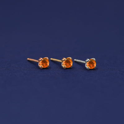 Three versions of the orange Fire Opal Earring shown in options of rose, yellow, and white gold