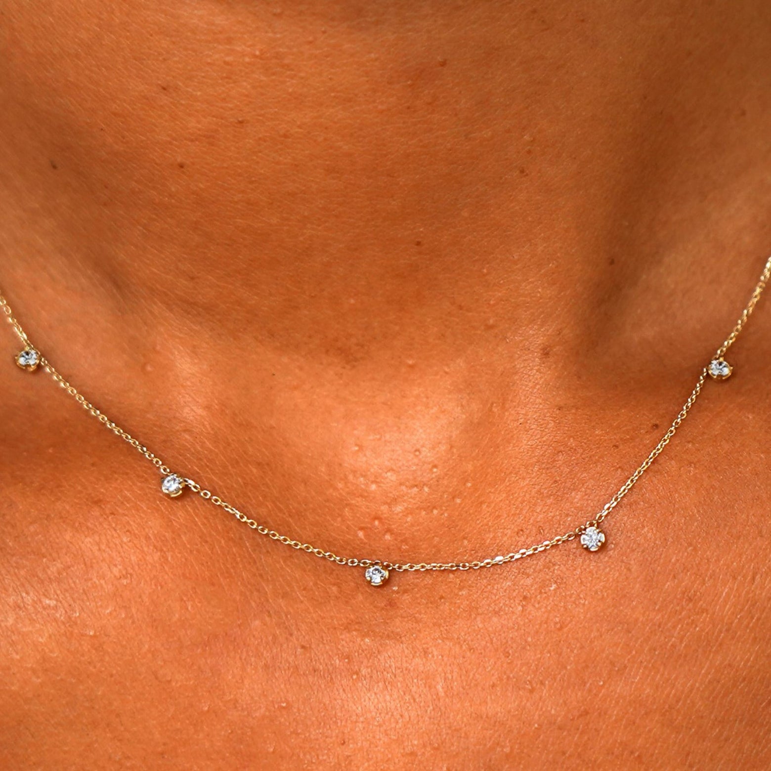 Close up view of a model's neck wearing a solid 14k yellow gold 5 Diamond Cable Necklace