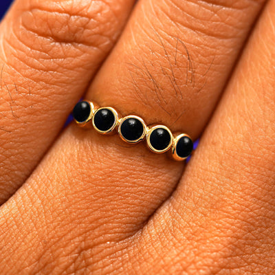 Close up view of a model's hand wearing a yellow gold 5 Gemstones Ring in onyx
