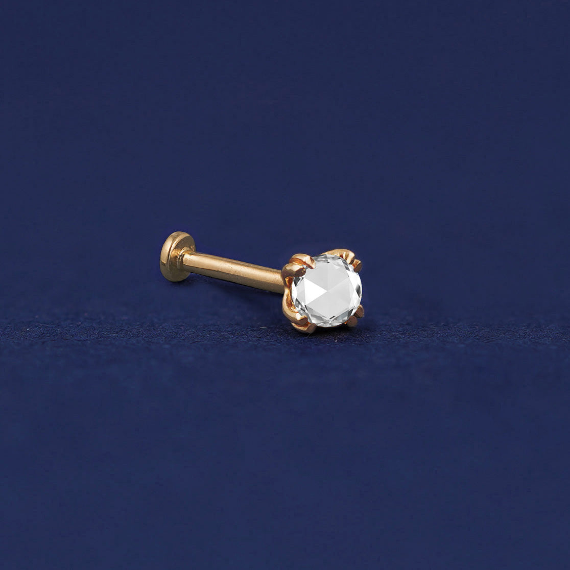 A 14 karat solid gold Rose Cut Diamond Flat Back Earring on a dark blue background