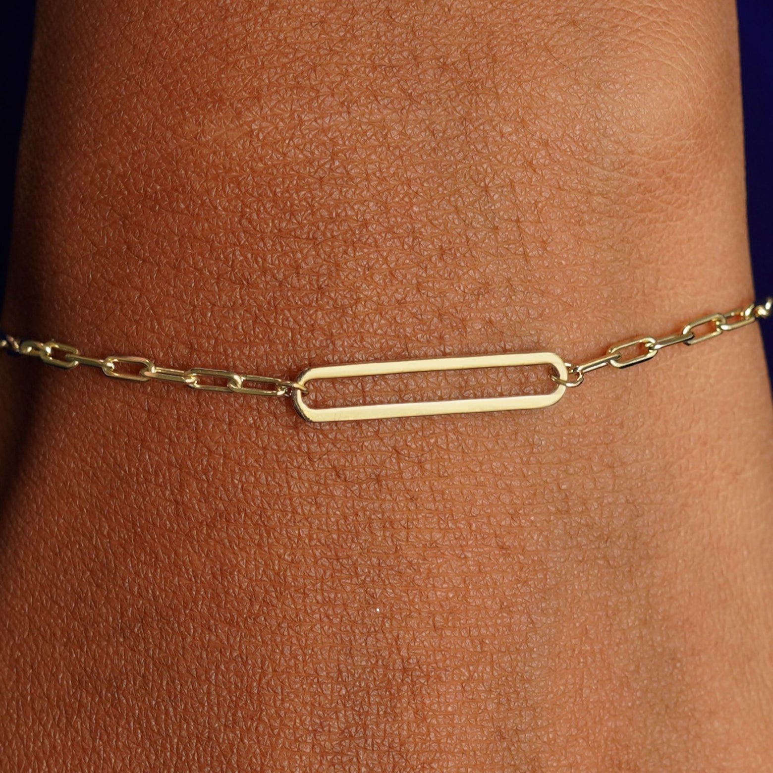 Close up view of a model's wrist wearing a yellow gold Floating Oval Bracelet