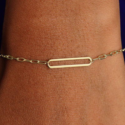 Close up view of a model's wrist wearing a yellow gold Floating Oval Bracelet