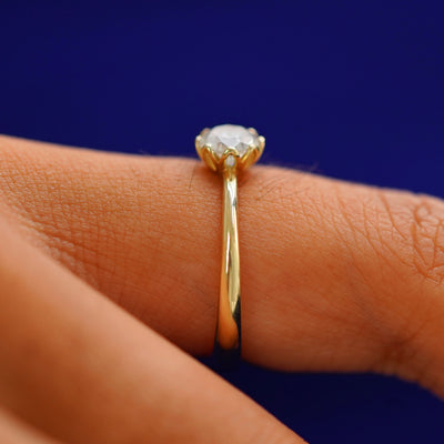 Side view of a Diamond Petal Ring on a model's finger