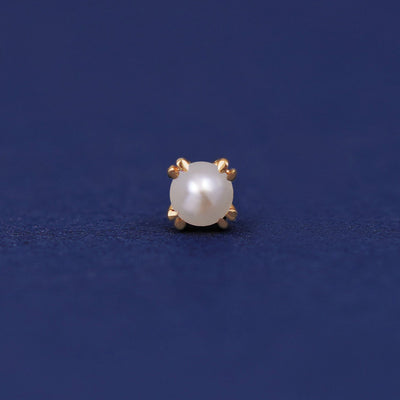 A 14 karat gold stud earring with a 3 millimeter round white freshwater cultured pearl