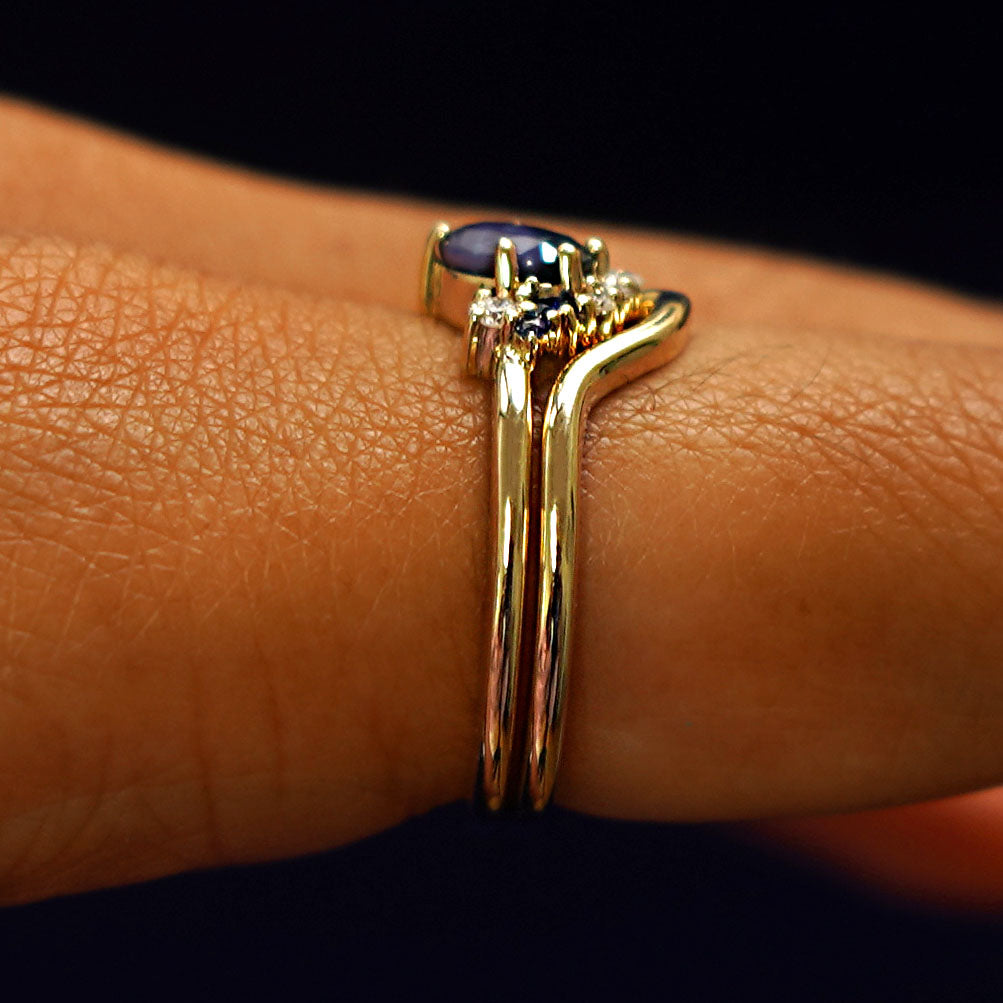 Side view of an Sapphire and Diamond Cluster Ring Set on a model's finger