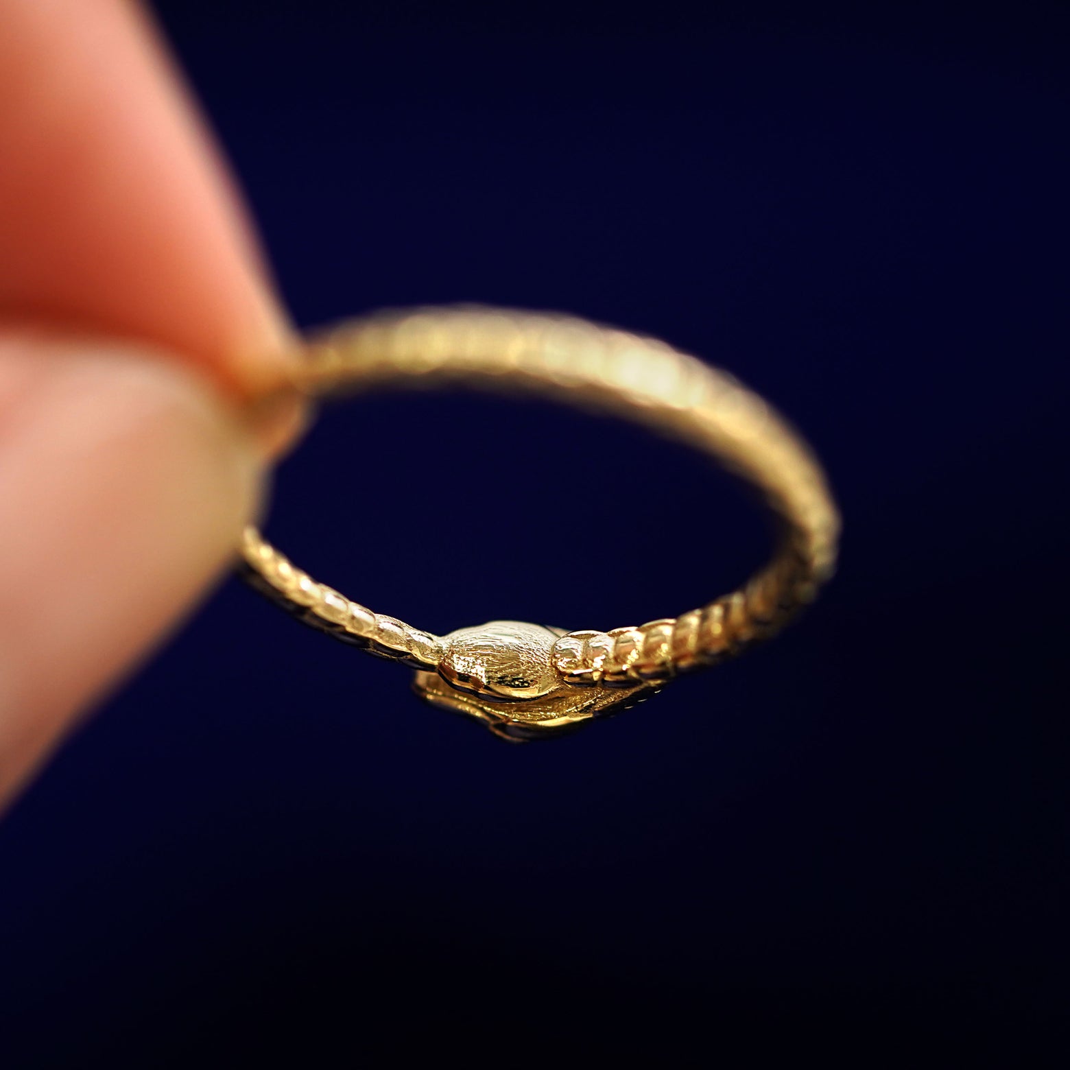 Underside view of a solid 14k gold Gemstone Ouroboros Snake Ring to show under the snake's head