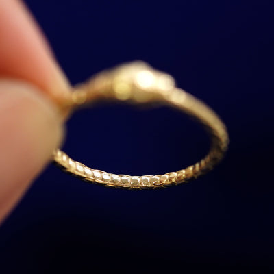 Underside view of a solid 14k gold Gemstone Ouroboros Snake Ring to show scale detailing on the band