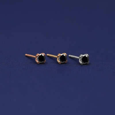 Three versions of the Black Diamond Earring shown in options of rose, yellow, and white gold
