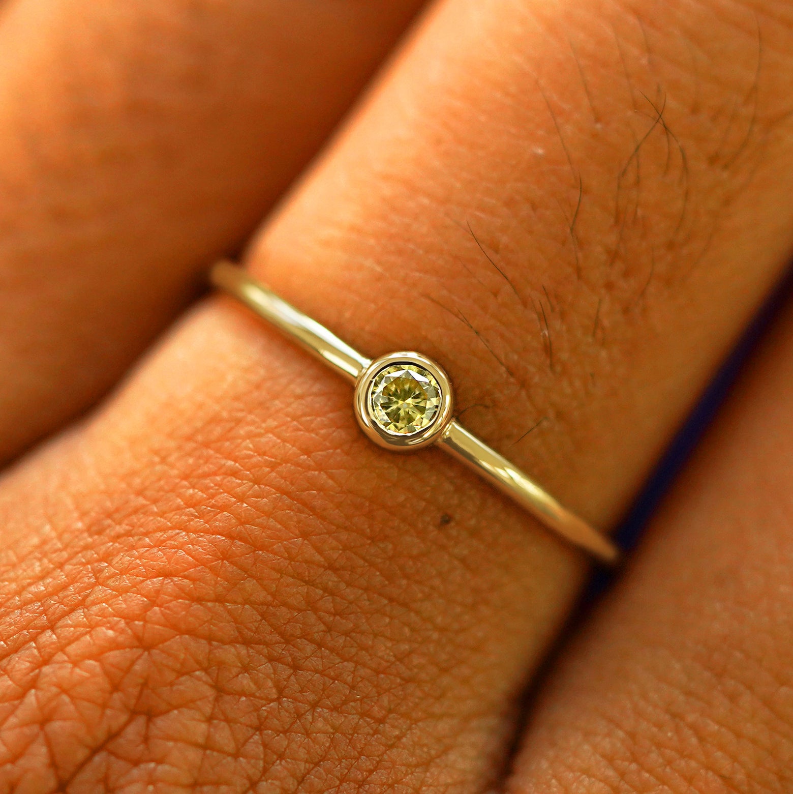Close up view of a model's fingers wearing a 14k yellow gold Champagne Diamond Ring