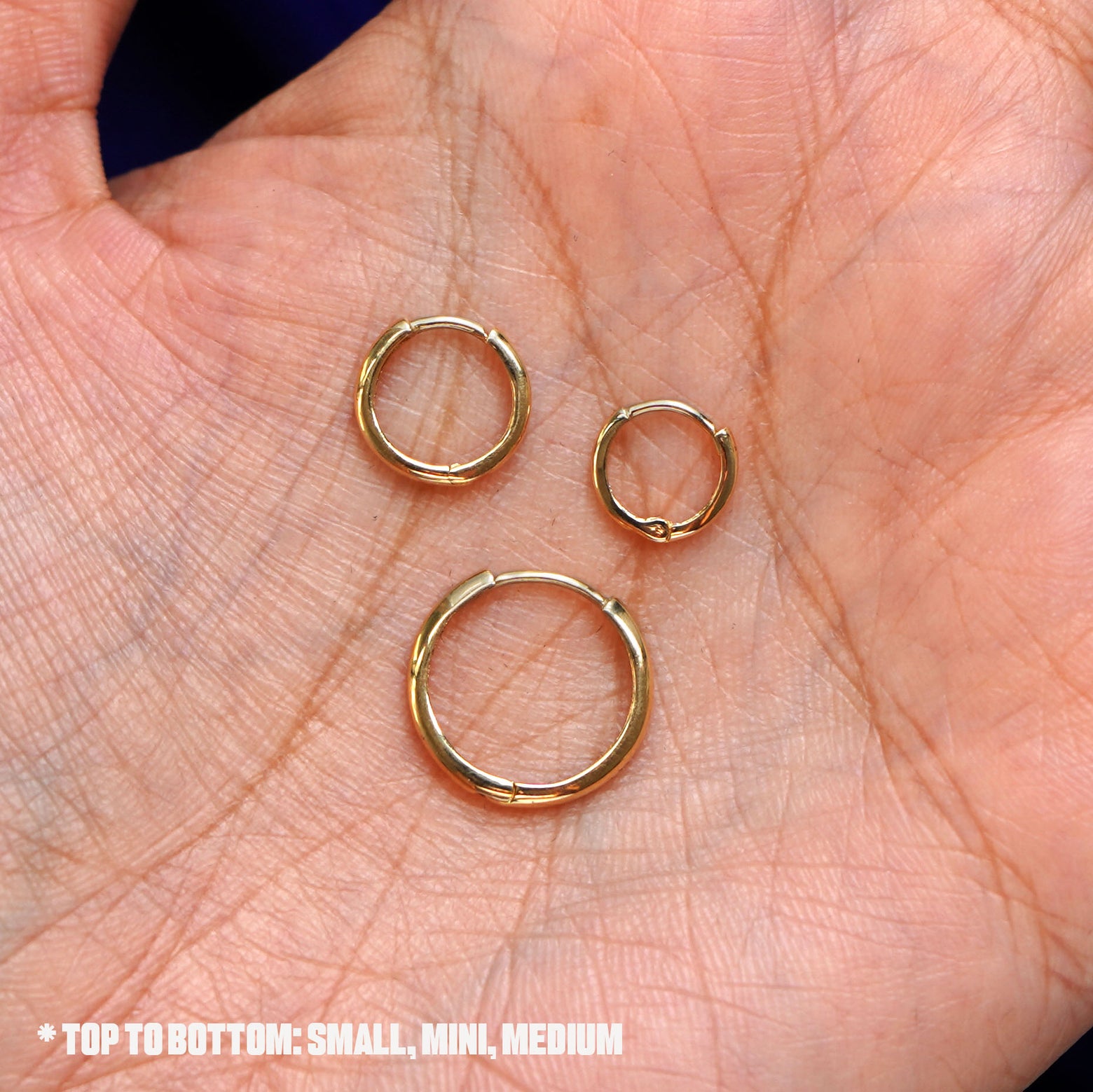 Three versions of the Curvy Huggie Hoops shown in medium, small, and mini sizes