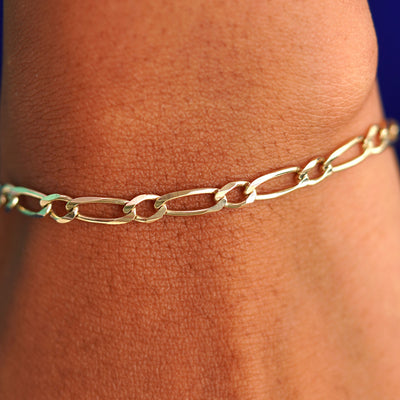 Close up view of a model's wrist wearing a yellow gold One to One Chain Bracelet