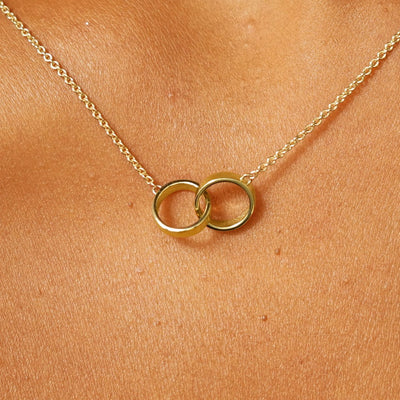 Close up view of a model's neck wearing a yellow gold Bound Together Necklace