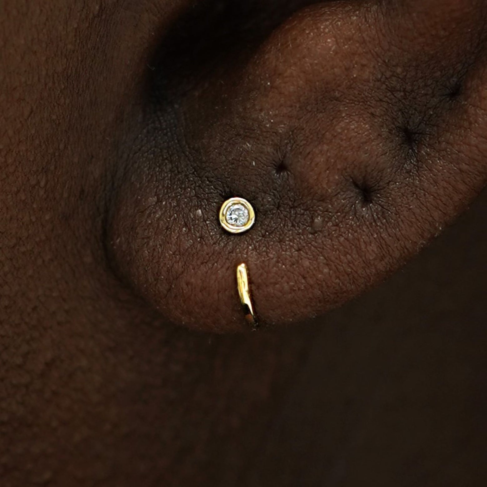 Close up view of a model's ear wearing a 14k gold Diamond Open Hoop Earring