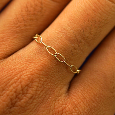 Close up view of a model's fingers wearing a 14k yellow gold Veren Ring