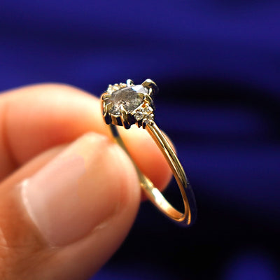 A model holding a Pear Salt and Pepper Diamond Ring tilted to show the details of the ring