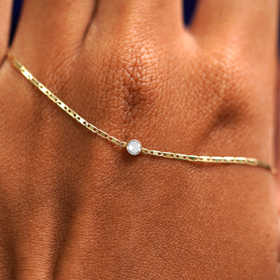 A solid gold Rose Cut Diamond Bracelet resting on the back of a model's hand