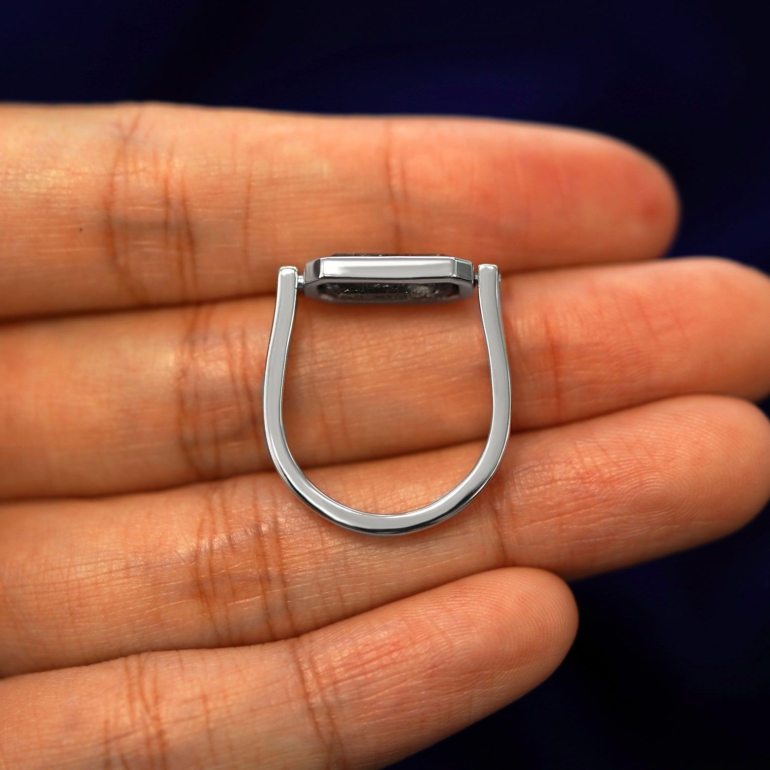 A white gold Salt and Pepper Diamond Spinner Ring in a model's hand showing the thickness of the band