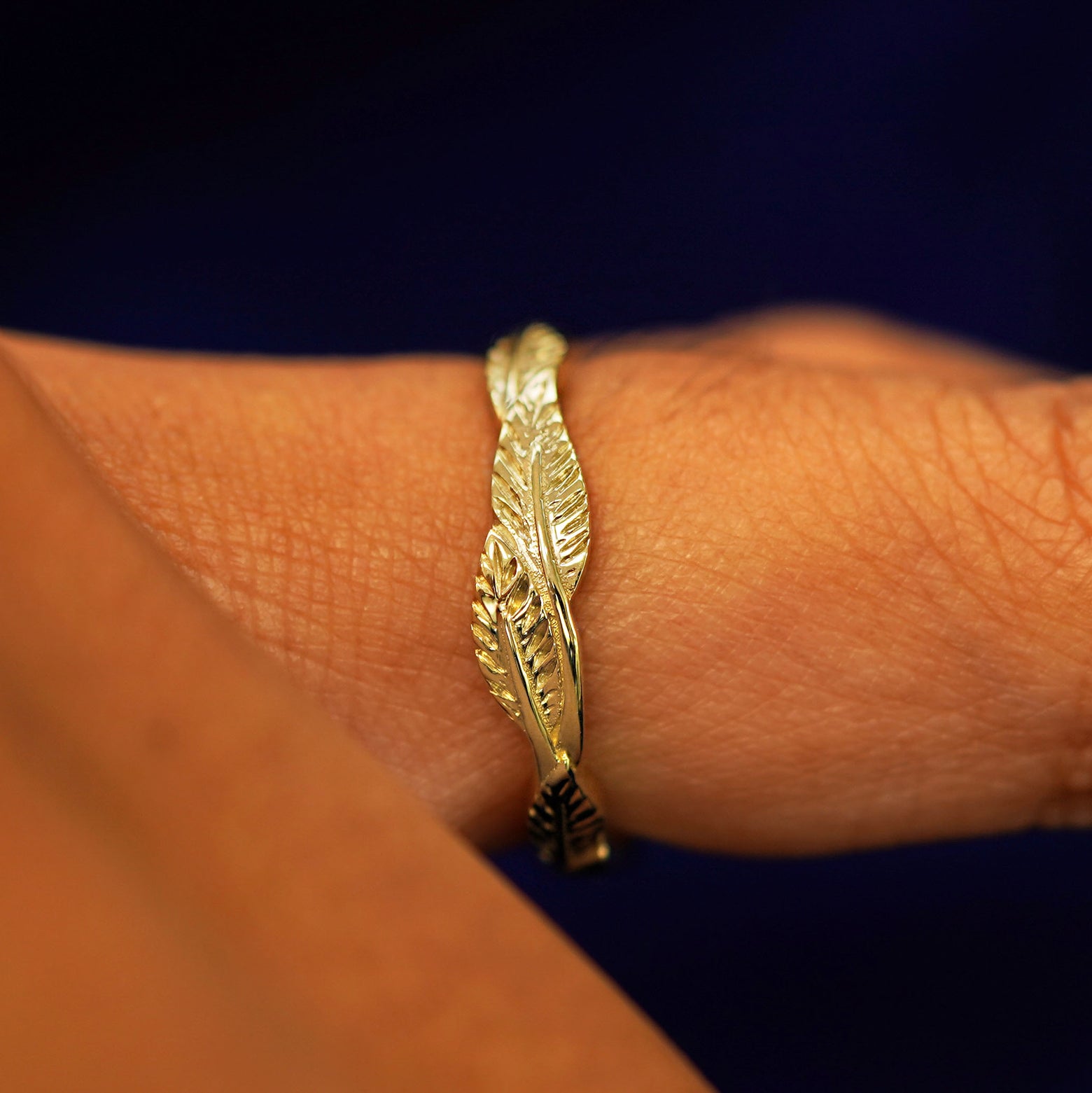 Side view of a Thick Leaves Band on a model's finger to show details