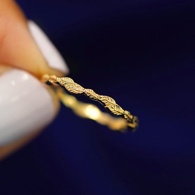 A model holding a Thin Leaves Band tilted to show the side of the band