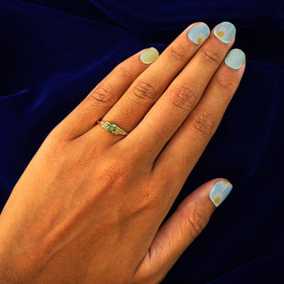 Close up view of a model's hand wearing a yellow gold Green Diamond Leaves Ring