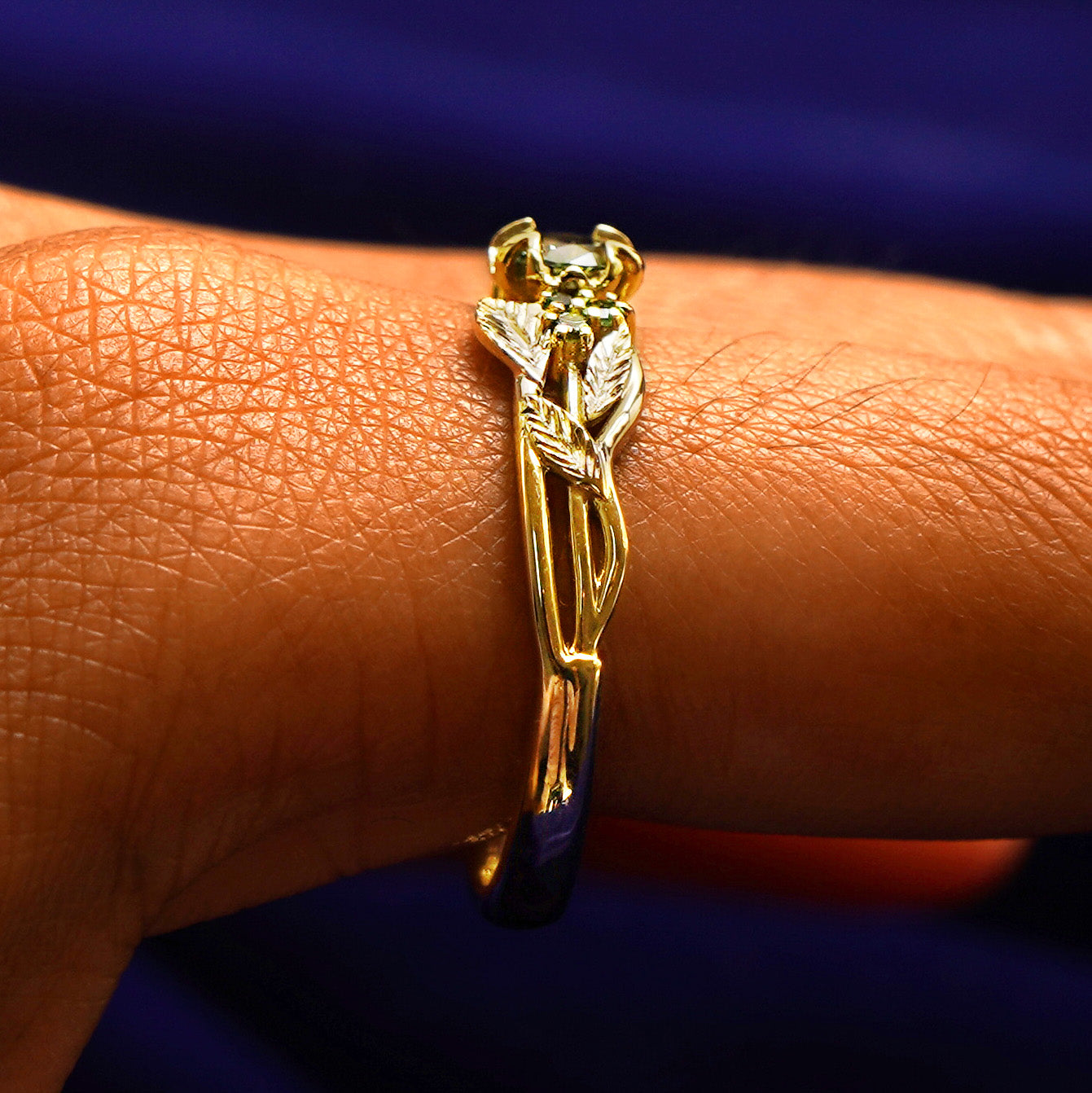 Side view of a Green Sapphire Leaves and Vines Ring on a model's finger